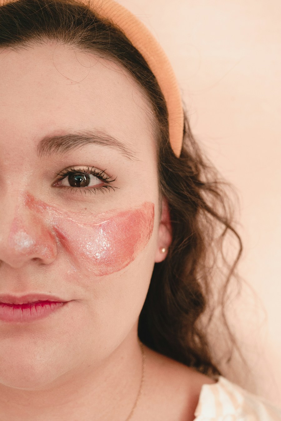 Mulher com máscara facial rosada olhando pra câmera