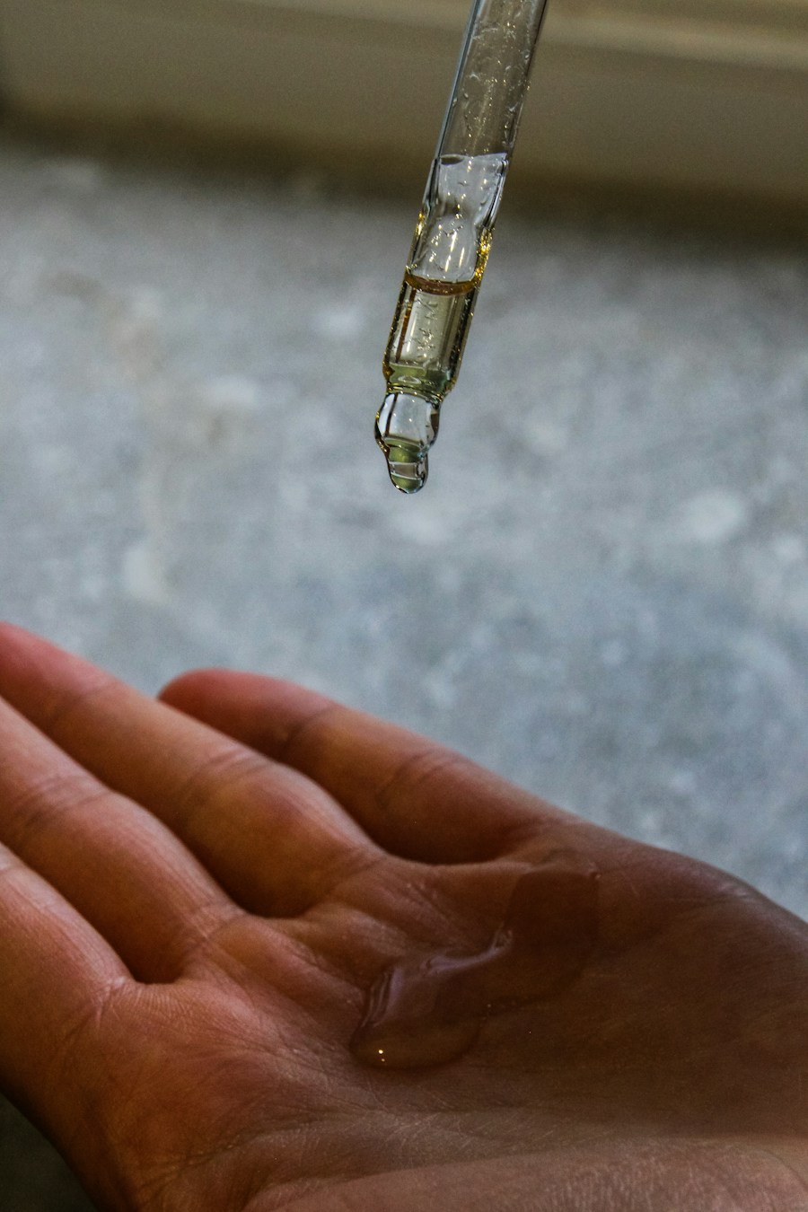 Gota de sérum caindo sobre a palma da mão
