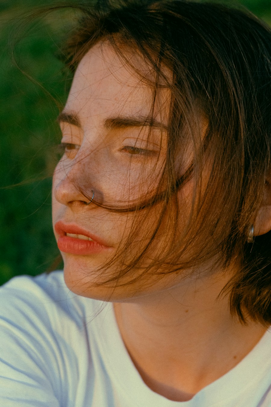 Mulher de perfil com sardas, ao ar livre