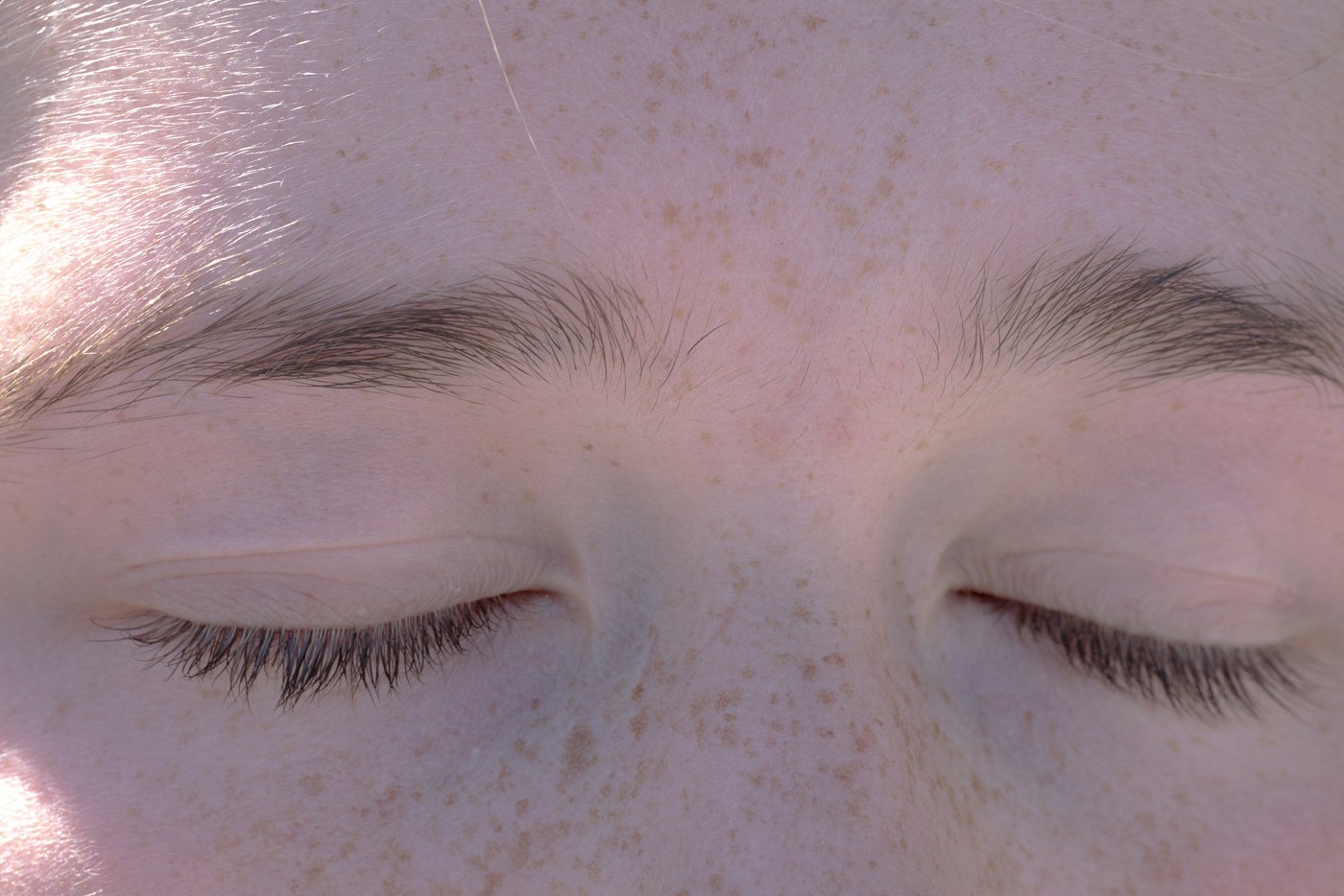 Close da testa e dos olhos fechados, com sardas